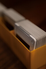 Stack of vintage photographic slides in a yellow storage box, evoking nostalgia and memories of the past