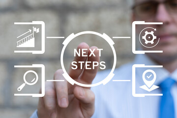 Business person using virtual touch screen push the inscription: NEXT STEPS. Next Steps Business Progress Development Career Concept.