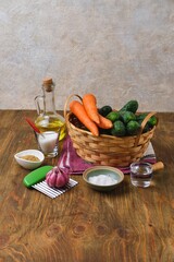 Prepared ingredients for making pickled cucumber and carrot salad on a wooden background. Home canning, preparations.