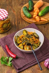 Pickled vegetable salad of cucumbers and carrots on a black fork. Canning, preparations. Step-by-step recipes.