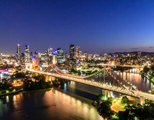 Fototapeta premium City skyline at night, illuminated bridge over river
