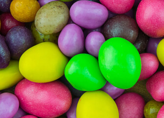 confectionery background sweets with multicolored sugar icing dragee green red lilac festive base...