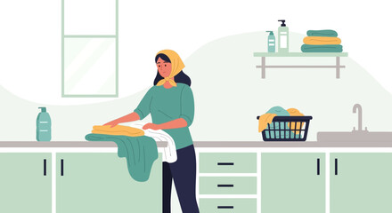 Woman Folds Fresh Laundry After Washing in a Bright and Clean Laundry Room