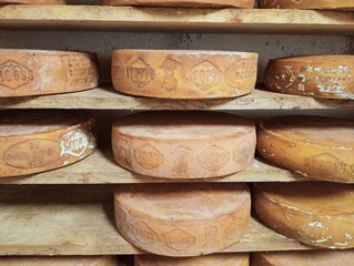 iew of an inside of a dairy with racks full of forms of cheese