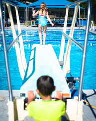 Motion blurry boys follow confident diver takes the lead. Motion blur adds depth, suggesting the playful rush, anticipation of childhood pool day ritual, outdoor community pool in Dallas, Texas