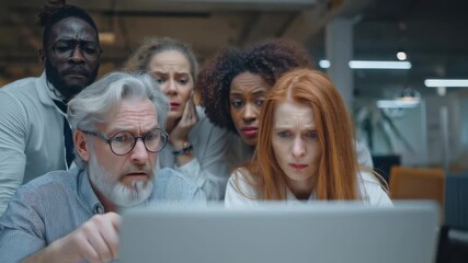 worried croup of diverse people colleagues focused on laptop screen in office environment  