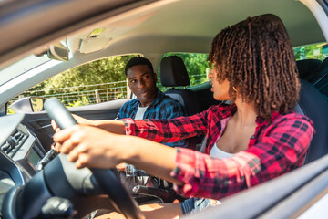 Driving instructor explaining lesson to student during driving test inside car