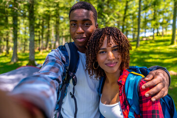 Hikers taking selfie in forest during sunny day