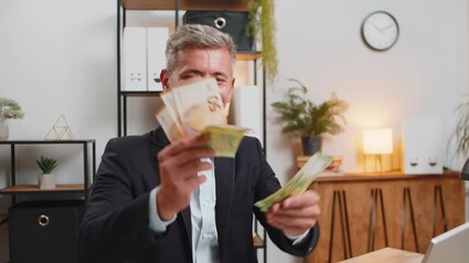 Caucasian young businessman holding fan of cash money euro banknotes celebrate, success career, lottery jackpot game winner, big income, wealth at home office workplace desk. Remote distant working. - Powered by Adobe