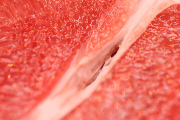 Detailed close-up photo of juicy red grapefruit slices. Macro photo of citrus fruits