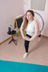 An adult woman performing warm-up exercises during an invigorating fitness training session in...