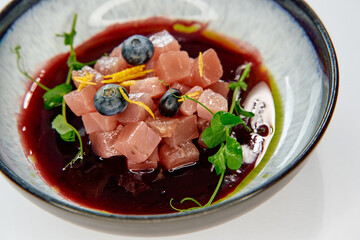 A Gourmet Array of Cubed Ingredients Dressed with Fresh Herbs and Bright Berries in Vibrant Sauce...
