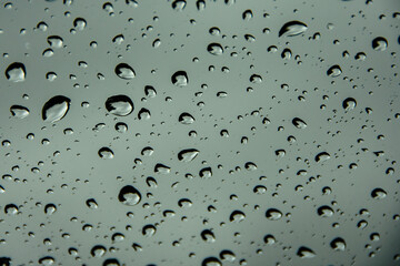Rain drops on windshield creating irregular patterns and shapes. Shallow depth of fiels.