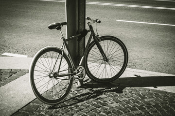 Black and white close up shot of an old bicycle. Old rusty vintage bicycle near the road.