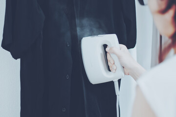 スチームアイロンをかける女性