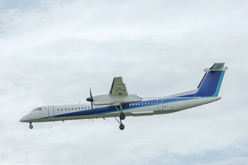 明るい夏の日差しの下で福岡空港に着陸する旅客機