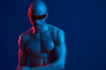 muscular man with futuristic sunglasses, glowing blue skin, and dramatic lighting creates a...