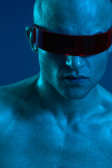 Futuristic man with visor in a striking blue light, showcasing strong emotions and an intense look....