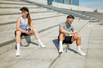 Friends enjoy a break during a workout session at a modern urban park