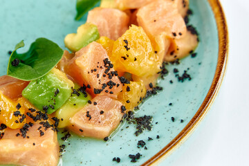 Deliciously Crafted Salmon Tartare with Citrus Segments, Avocado, and a Touch of Black Salt Served on a Stylish Plate for Culinary Delight
