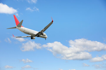 Airplane flying in beautiful blue sky with clouds