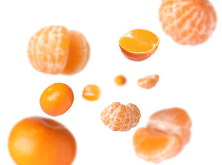 Juicy tangerines swirling in air against white background