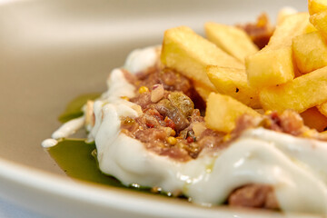 A Delicious Plate of Crispy Fries Served Alongside Creamy Dip Garnished with Spices and Flavorful Ingredients for an Irresistible Culinary Experience