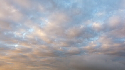 Expansive sky filled with soft, fluffy clouds in various shades of blue and gray, creating a serene atmosphere and inviting tranquility for nature lovers and photographers alike
