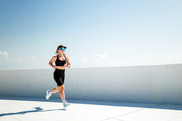 Running under a clear sky with determination and focus in a vibrant city