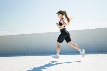 Energetic runner enjoying a sunny workout on a rooftop