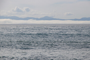 Ocean meeting cloud covered mountains
