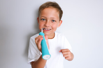 Cheerful young boy brushing teeth in bathroom. Morning hygiene routine, dental care and healthy...