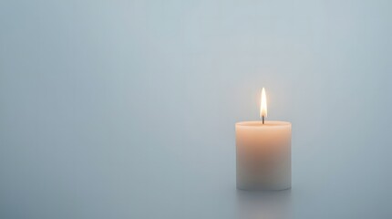 A lone candle glows softly in the dim light, casting a warm and comforting ambiance.