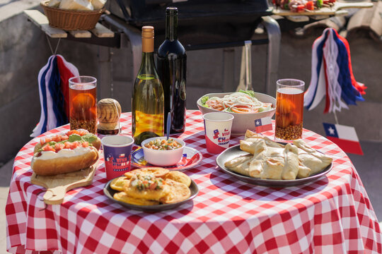 Chilean Independence Day: Independence Day celebration table with traditional empanadas, wine, chicha and patriotic decorations