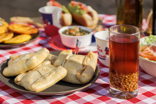 Chilean Independence Day: Close-up of empanadas, mote con huesillo and pebre on traditiona