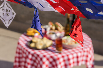 Chilean Independence Day: papel picado garland in foreground with traditional food table in background
