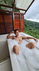 Handsome Man Relaxing on Holiday with Lush Green Valley and Misty Mountain Views in Chiang Mai, Thailand