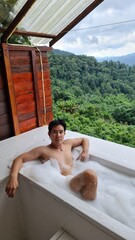 Handsome Man Relaxing on Holiday with Lush Green Valley and Misty Mountain Views in Chiang Mai, Thailand