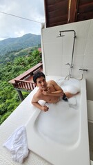 Handsome Man Relaxing on Holiday with Lush Green Valley and Misty Mountain Views in Chiang Mai, Thailand