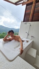 Handsome Man Relaxing on Holiday with Lush Green Valley and Misty Mountain Views in Chiang Mai, Thailand