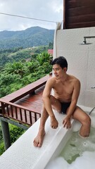 Handsome Man Relaxing on Holiday with Lush Green Valley and Misty Mountain Views in Chiang Mai, Thailand