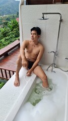 Handsome Man Relaxing on Holiday with Lush Green Valley and Misty Mountain Views in Chiang Mai, Thailand