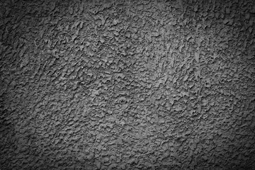 Dark grey or black cement wall background with embossed rough patterns