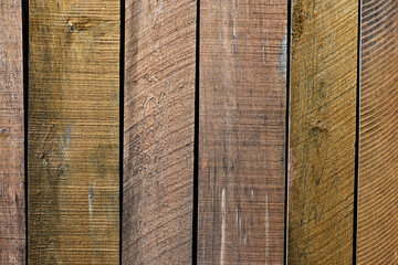 Rustic vertical wooden planks with natural grain and weathered texture. Earthy brown tones ideal for backgrounds, design projects, architecture themes, or organic construction materials.
