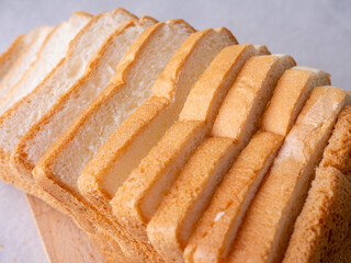 Toasted white bread loaf sliced on white background.