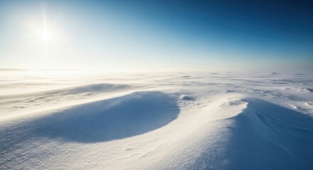 Vast frozen landscape under a bright sky with drifting snow and subtle sunlight illuminating the ground