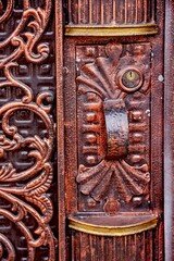 Ornate metal door featuring intricate carvings and a detailed handle, showcasing craftsmanship and artistry in design, perfect for architectural and decorative themes
