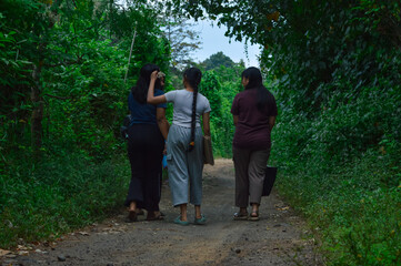 The girls continue walking together, chatting and enjoying each other's company under the shade of...