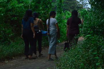 Four teens make their way through the tree-lined trail, calmly observing their surroundings while...