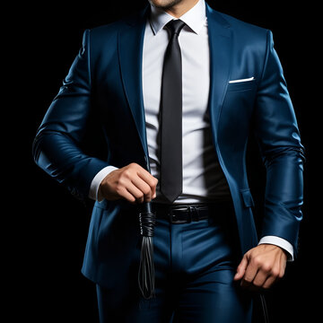 man dominant boss in a suit holds a leather flogger whip in hands for BDSM sex with domination and submission. Wide horizontal banner header with a copy space on black background